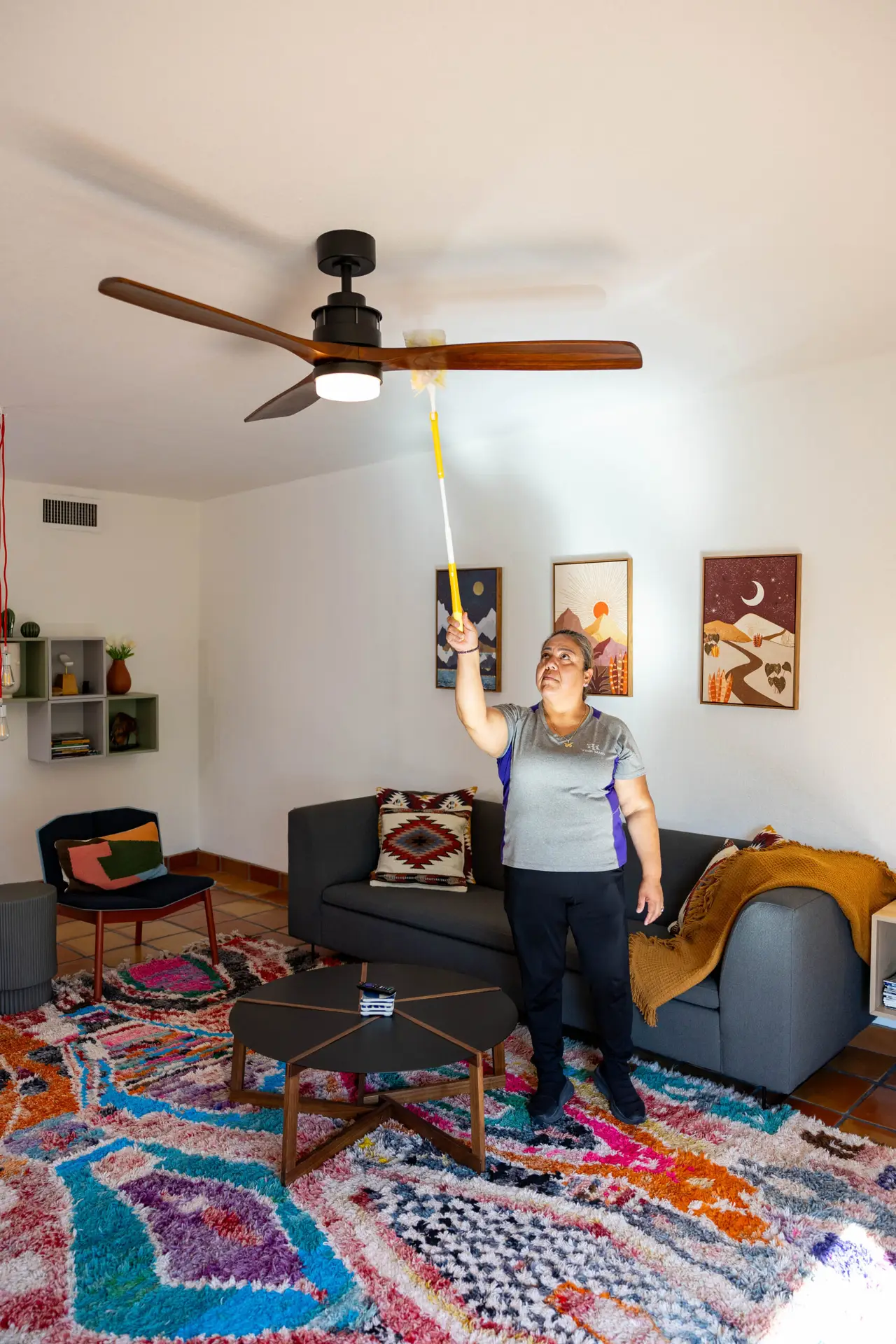 Staff member cleaning in the light under the ceiling fan